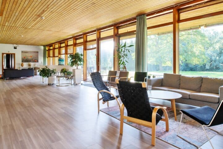 Sunnanå course venue: Spacious large room with large windows along the entire wall, outdoor sunny garden with two large trees